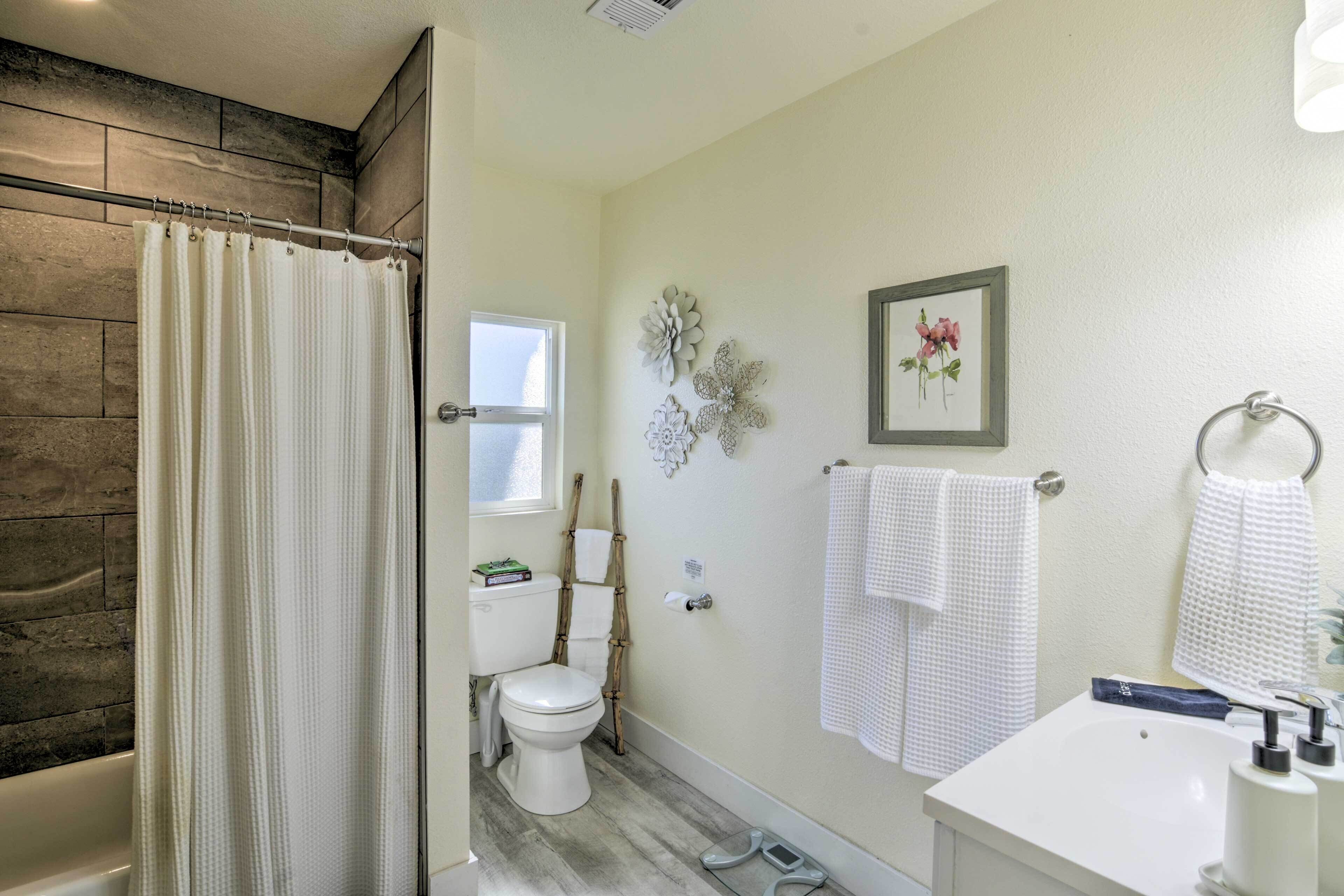 A bathroom with a toilet, a sink, and a shower area.