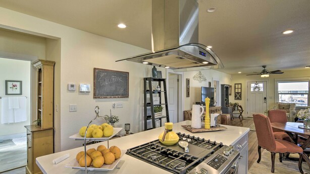 A modern kitchen with a central island, stainless steel appliances, and a dining area with wooden chairs. - Ideally Located Chico Home - Fire Pit & Grill (Chico)