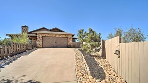 A house with a stone facade, a garage, and a wooden fence.