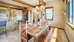 A spacious kitchen with wooden cabinetry, a large island, and a dining area with a wooden table and benches.