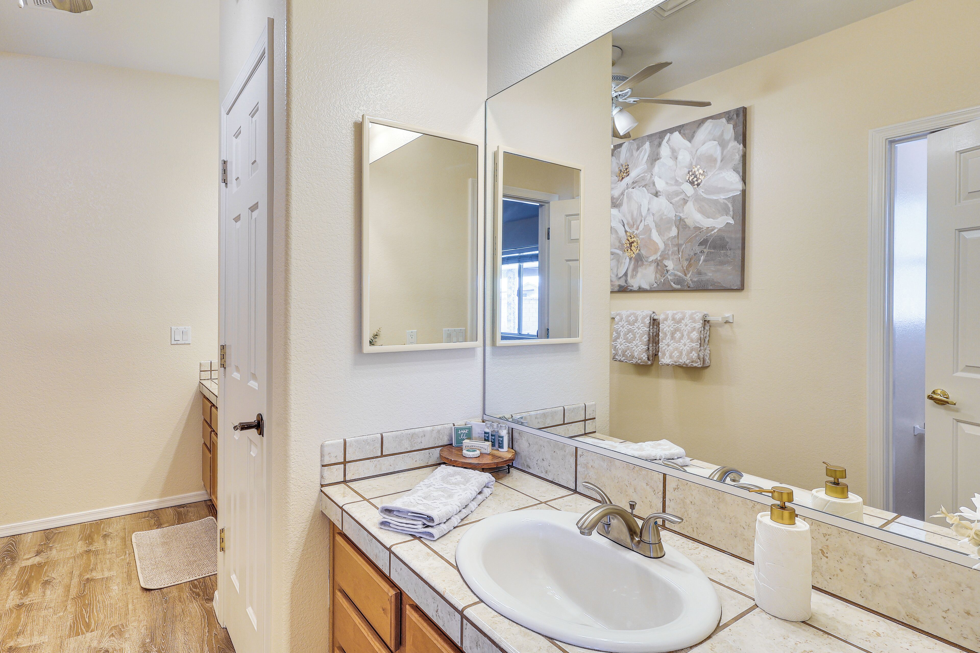 Une salle de bain avec un lavabo, un miroir et un porte-serviettes.
