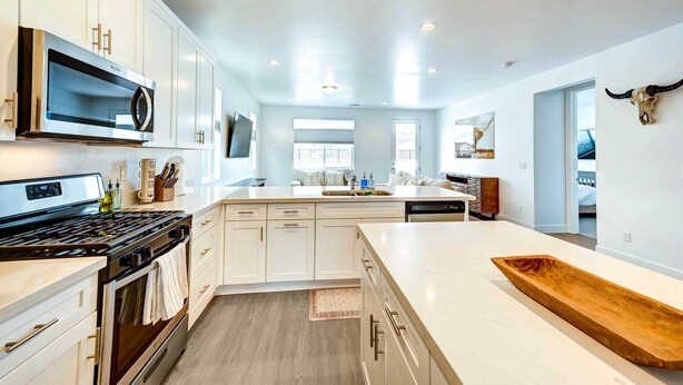 A modern kitchen with white cabinetry, a large island, and a bull skull decoration. - 12 Mi to Dtwn Flagstaff: Spacious Bellemont Home! (Bellemont)