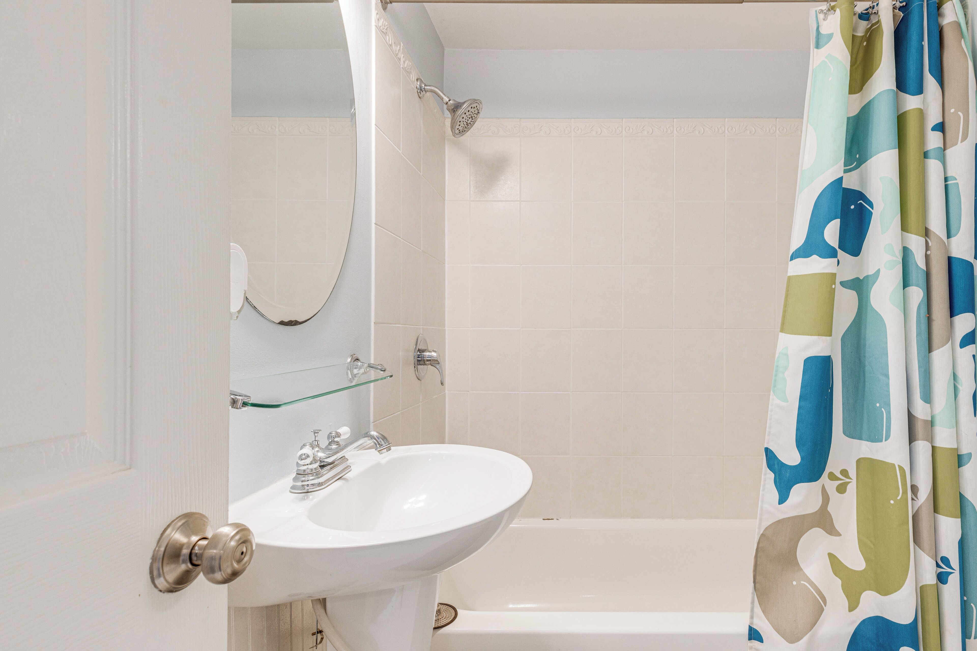 A bathroom with a white sink, a glass shower enclosure, and a bathtub.
