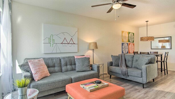 A modern living room with grey sofas, a coffee table, and a ceiling fan. - Mountain-view Tucson Condo w/ Outdoor Pools! (Tucson)