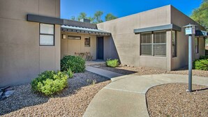 A modern building with a flat roof, a covered outdoor seating area, and a gravel pathway leading to the entrance. - Mountain-view Tucson Condo w/ Outdoor Pools! (Tucson)