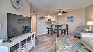 A living room with a TV, a coffee table with starfish, a sofa, and a dining area with chairs and a table. - Walk to Bradenton Beach: Gulf-view Home w/ Lanai (Bradenton Beach)