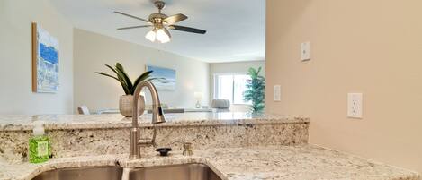 A kitchen with granite countertops, stainless steel sink, and a dishwasher.