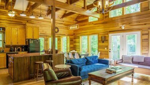 A spacious cabin interior with a kitchen, dining area, and seating.