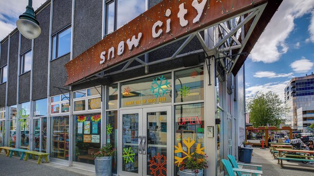 A storefront with a sign reading "snow city" and a neon "OPEN" sign. - Water-view Retreat! Steps to Coastal Trail & Dtwn (Anchorage)