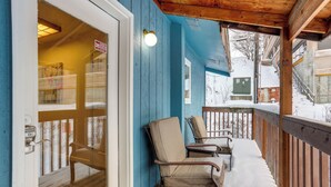 A wooden deck with chairs, a door, and a blue wall. - Water-view Retreat! Steps to Coastal Trail & Dtwn (Anchorage)