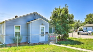 A single-story house with a fenced yard, a tree, and a parked truck.