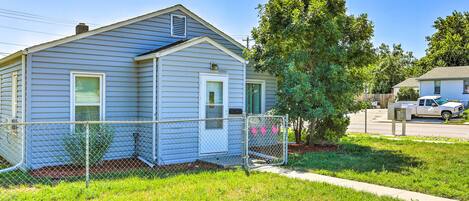 A single-story house with a fenced yard, a tree, and a parked truck.
