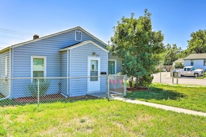 A single-story house with a fenced yard, a tree, and a parked truck.