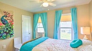 A bedroom with a bed, a ceiling fan, a window with curtains, a wall-mounted artwork, and a bedside lamp. - Modern Rapid City Duplex < 10 Mi to Natl Forest! (Rapid City)