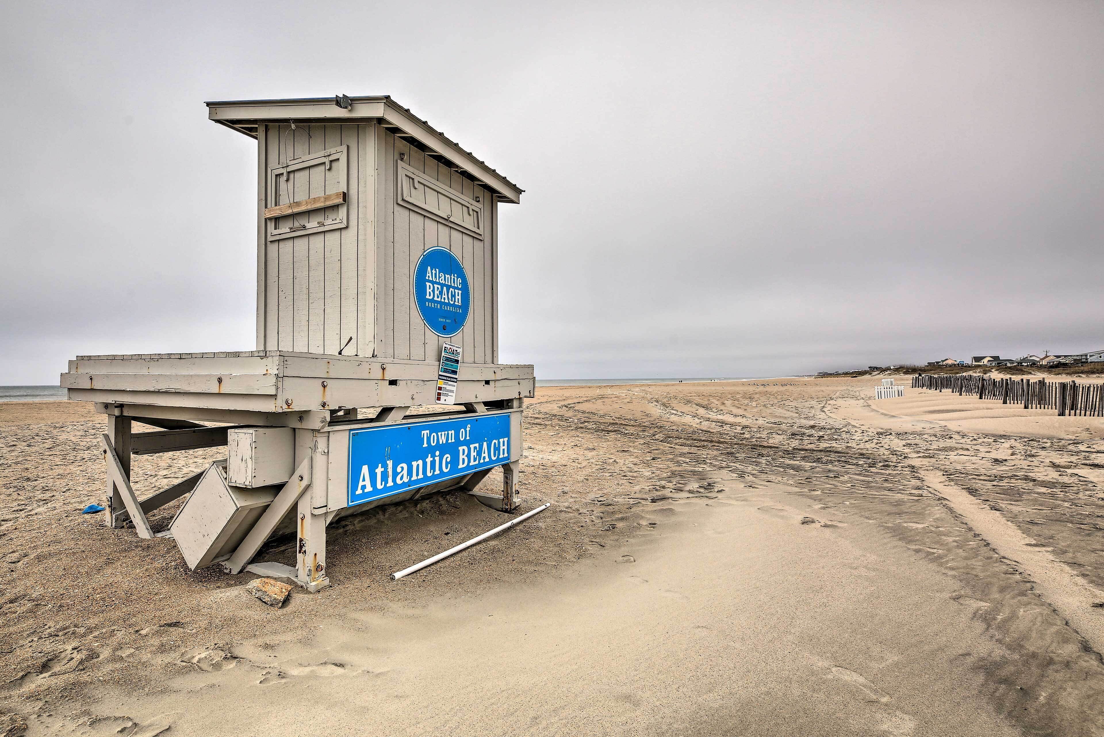 Une tour de surveillance, portant l’inscription « Ville d’Atlantic Beach », se dresse sur une plage de sable.