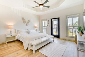 A bedroom with a bed, bedside tables, a ceiling fan, a bench, and a view of the outside. - Panama City Vacation Rental - 6 Mi to Downtown! (Panama City)