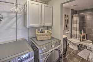 A compact laundry area with a washing machine and dryer, a small sink, and a toilet. - Serene Havasu Oasis: Newly Remodeled w/ Views (Lake Havasu City)