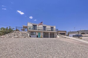 A two-story house with an American flag, a turquoise door, and a garage. - Serene Havasu Oasis: Newly Remodeled w/ Views (Lake Havasu City)