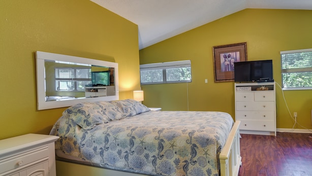 A bedroom with a bed, a dresser, a TV, and a window. - St Petersburg Vacation Home 6 Mi to St Pete Beach! (St. Petersburg)