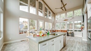 A spacious kitchen with a large island, multiple windows, and a ceiling fan. - Hot Tub + Deck: Mtn-view Pine Getaway! (Pine)