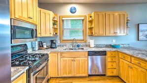 A kitchen with wooden cabinets, a stainless steel refrigerator, a stove, a dishwasher, and a window with blinds. - Waterfront Mound Retreat w/ Dock & Lake Access! (Mound)