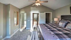 A bedroom with a large bed, a ceiling fan, and a view of a hallway. - Waterfront Mound Retreat w/ Dock & Lake Access! (Mound)