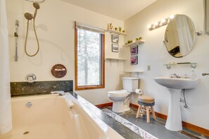 A modern bathroom with a bathtub, toilet, sink, and shower.