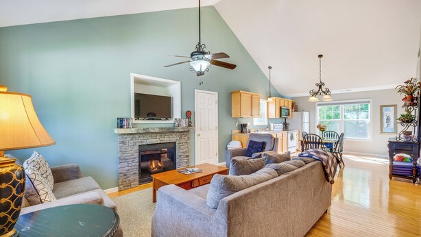 A spacious living room with a fireplace, a sofa set, and a dining area with chairs and a table. - Taylorsville Lake Cottage Rental w/ Hot Tub! (Taylorsville)