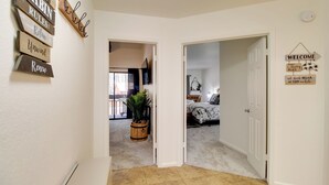 A hallway with a wooden sign reading "CABIN RULES: Relax, Unwind, Renew" and a welcome sign. - Forest-view Balcony: Pinetop-lakeside Condo (Pinetop)