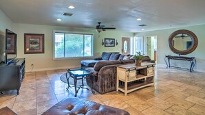 A spacious living room with a sectional sofa, a coffee table, and a ceiling fan. - Modern Glendale Desert Destination w/ Patio! (Glendale)