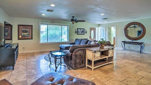 A spacious living room with a sectional sofa, a coffee table, and a ceiling fan. - Modern Glendale Desert Destination w/ Patio! (Glendale)