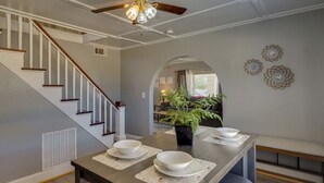 A dining area with a wooden table, white plates, and a potted plant. - Lamesa Vacation Rental w/ Covered Patio & Fire Pit (Lamesa)
