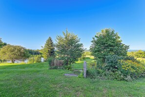 A grassy field with trees and a body of water in the distance. - Peaceful Marlboro Vacation Rental w/ Sauna & Yard! (Wilmington)