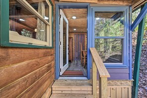A wooden cabin with a wooden staircase leading to a door, a window on the right, and a wooden railing. - Rosman Vacation Rental w/ Charcoal Grill! (Rosman)
