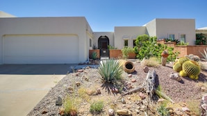 A modern house with a white garage, a front door, and a small garden with cacti and succulents. - Green Valley Abode w/ Pool Access & Mtn Views (Green Valley)
