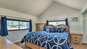 A bedroom with a large bed, two bedside tables, a wooden dresser, and a window with curtains. - Charming Miami Desert Escape w/ Yard + Patio! (Miami)