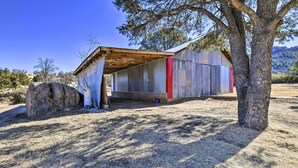 A rustic cabin with a metal exterior, a wooden roof, and a large rock nearby. - Charming Miami Desert Escape w/ Yard + Patio! (Miami)