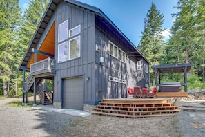 Ein modernes, zweistöckiges Haus mit Terrasse und Sitzbereich im Freien.
