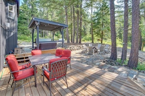 Eine Terrasse mit Grill, roten Stühlen und einem Tisch.