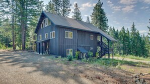 Un'ampia casa moderna in legno con tetto spiovente, numerose finestre e un portico coperto.