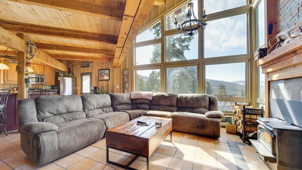 Amplia sala de estar con un sofá modular grande, una mesa de centro de madera y una chimenea de piedra.