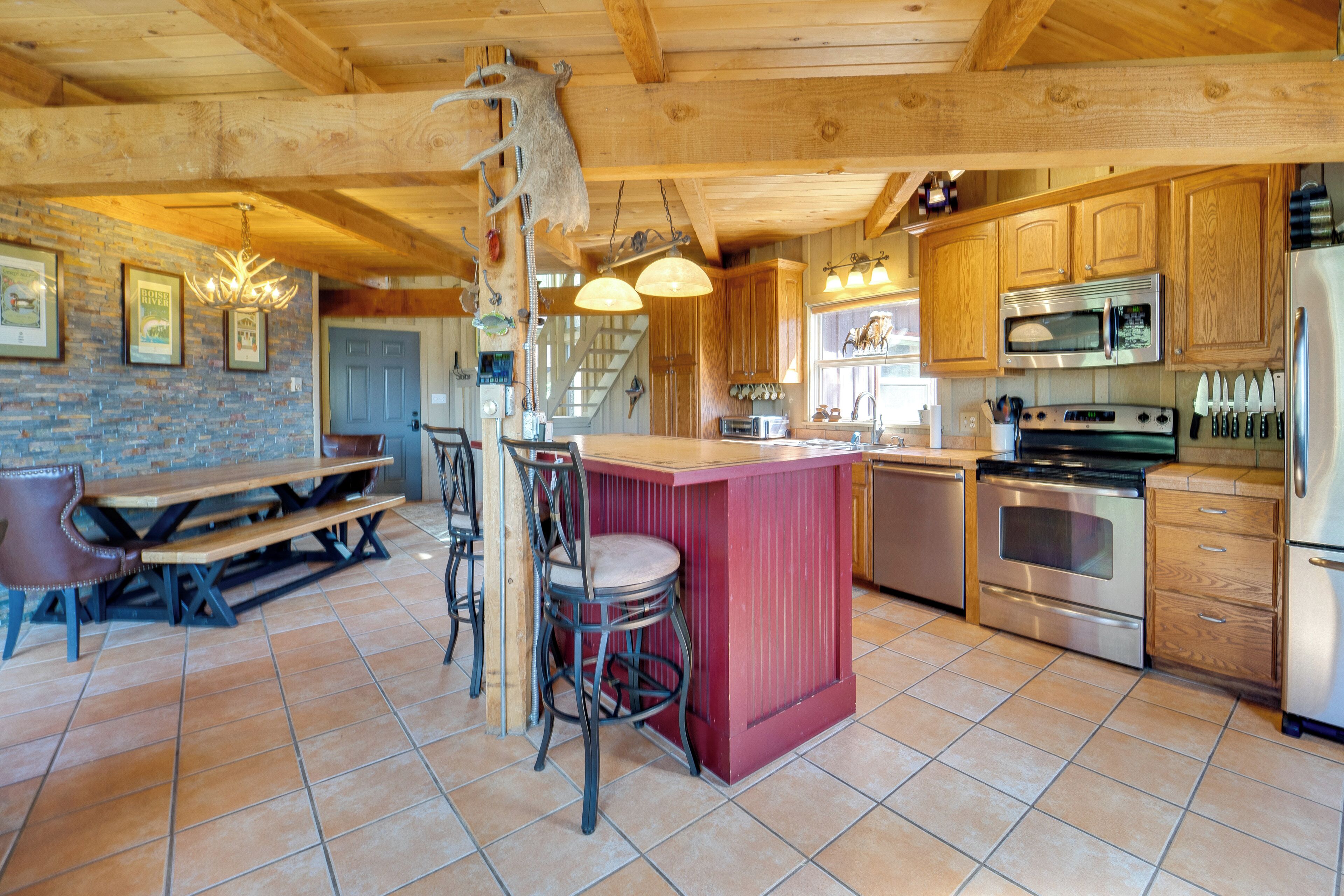 A spacious kitchen with wooden cabinets, a central island, and modern appliances including a refrigerator, microwave, and stove.