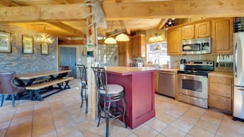A spacious kitchen with wooden cabinets, a central island, and modern appliances including a refrigerator, microwave, and stove.