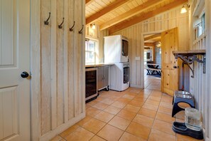 A kitchen with wooden walls, a tiled floor, and a refrigerator.