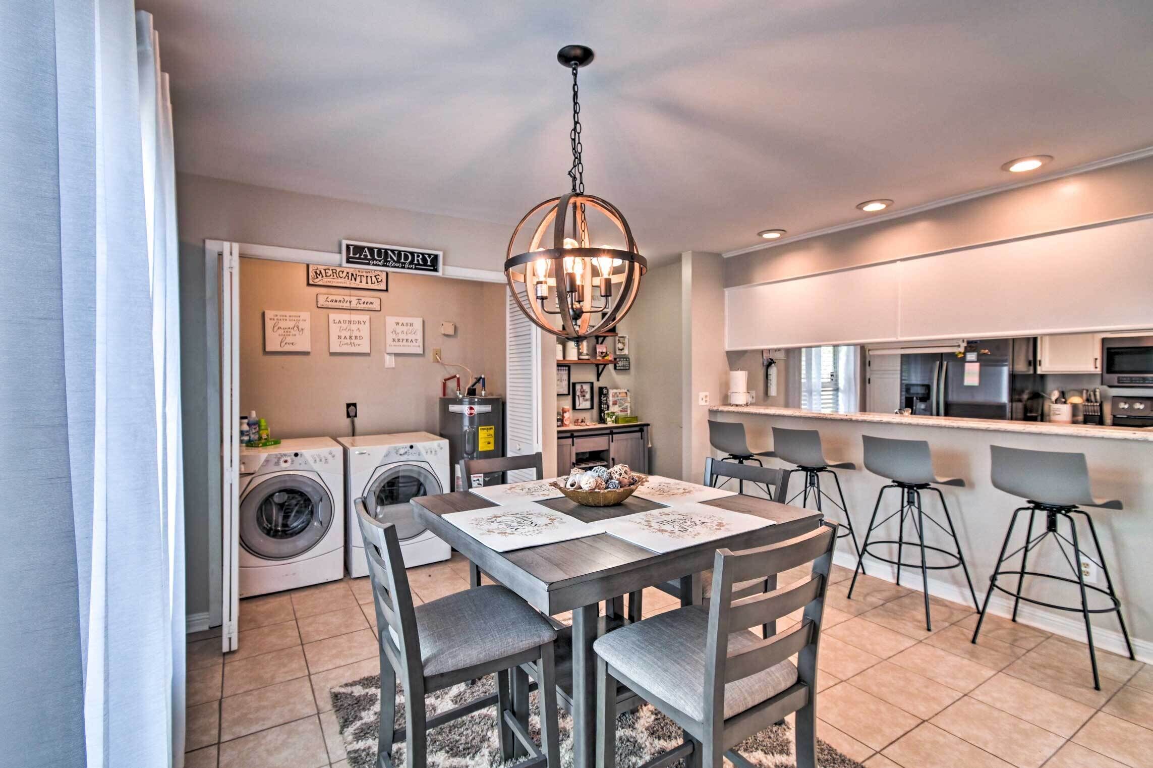 A modern kitchen with a central island, built-in appliances, and a dining area with a chandelier.