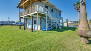 A two-story house with a balcony and a covered porch. - Waterfront Texas Abode w/ Boat Ramp, Pets Welcome (Bay City)