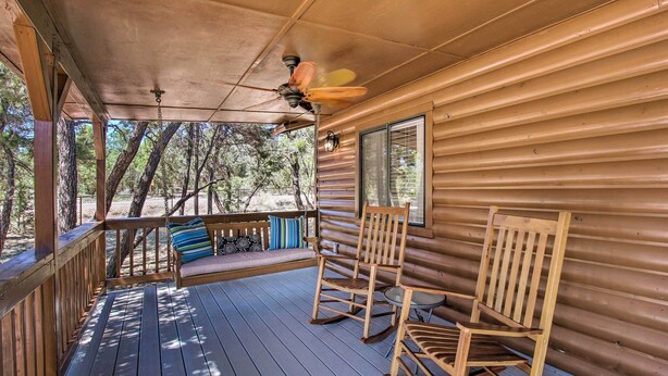 A wooden cabin with a porch, two rocking chairs, a bench, and a ceiling fan. - Cozy Heber Cabin Retreat w/ Deck + Fireplace! (Overgaard)