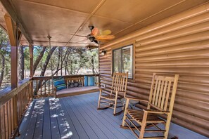 A wooden cabin with a porch, two rocking chairs, a bench, and a ceiling fan. - Cozy Heber Cabin Retreat w/ Deck + Fireplace! (Overgaard)