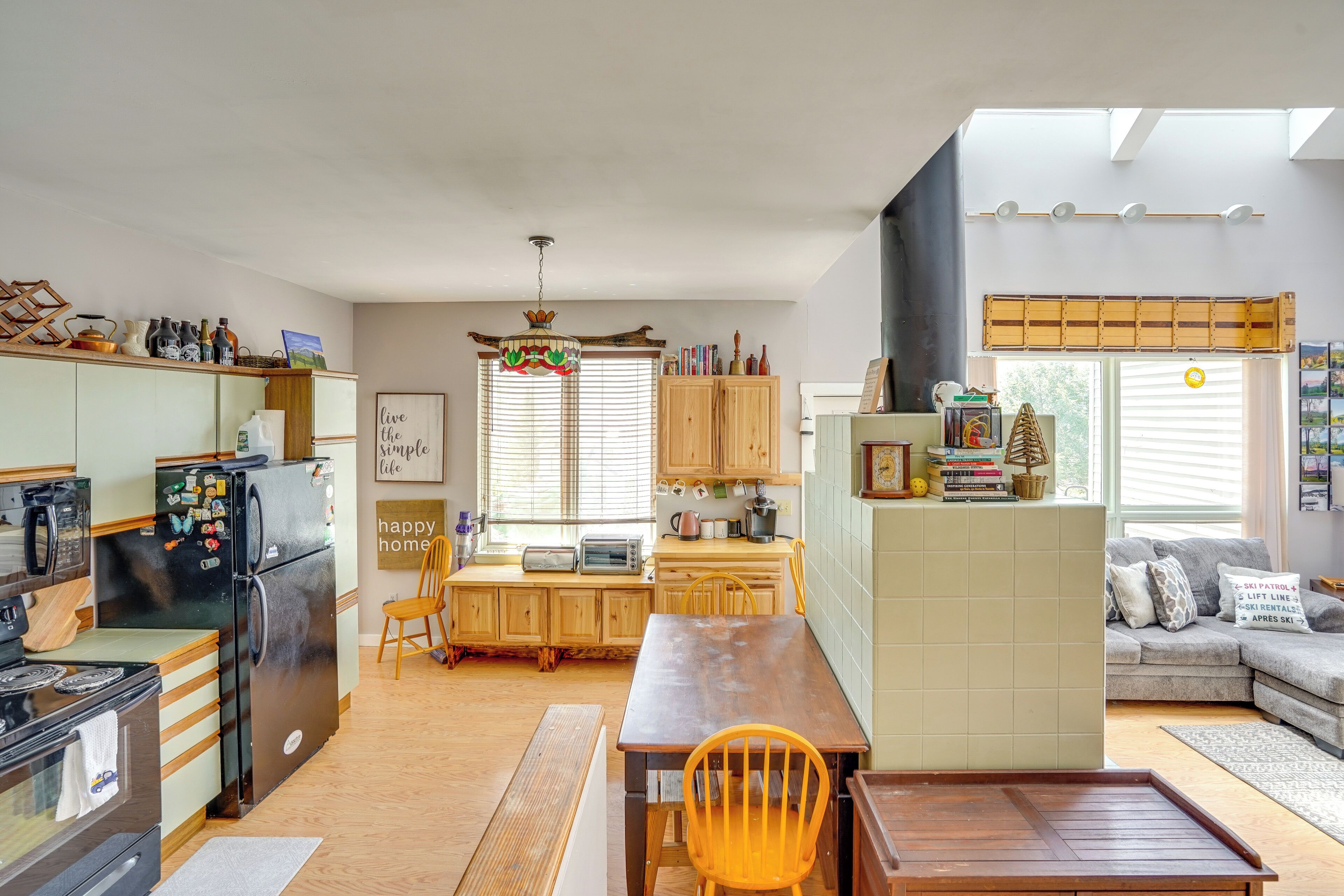 A compact kitchen with a dining area, wooden cabinets, and a built-in oven.