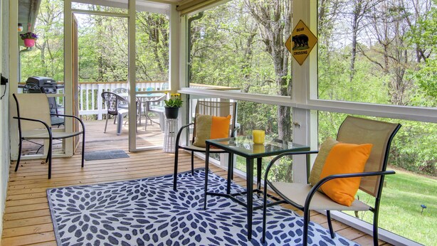 A covered outdoor area with a table and chairs, a grill, and a bear crossing sign. - Pet-friendly Black Mountain Vacation Home w/ Deck (Black Mountain)